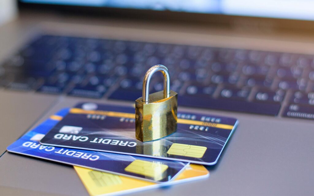 Credit cards stacked ontop of laptop with padlock