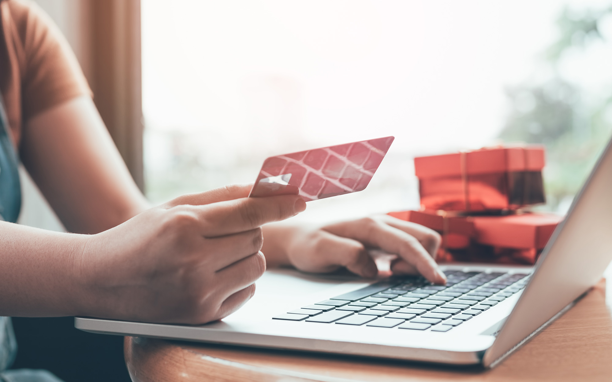 Close up woman hand holding credit card and typing laptop keyboard