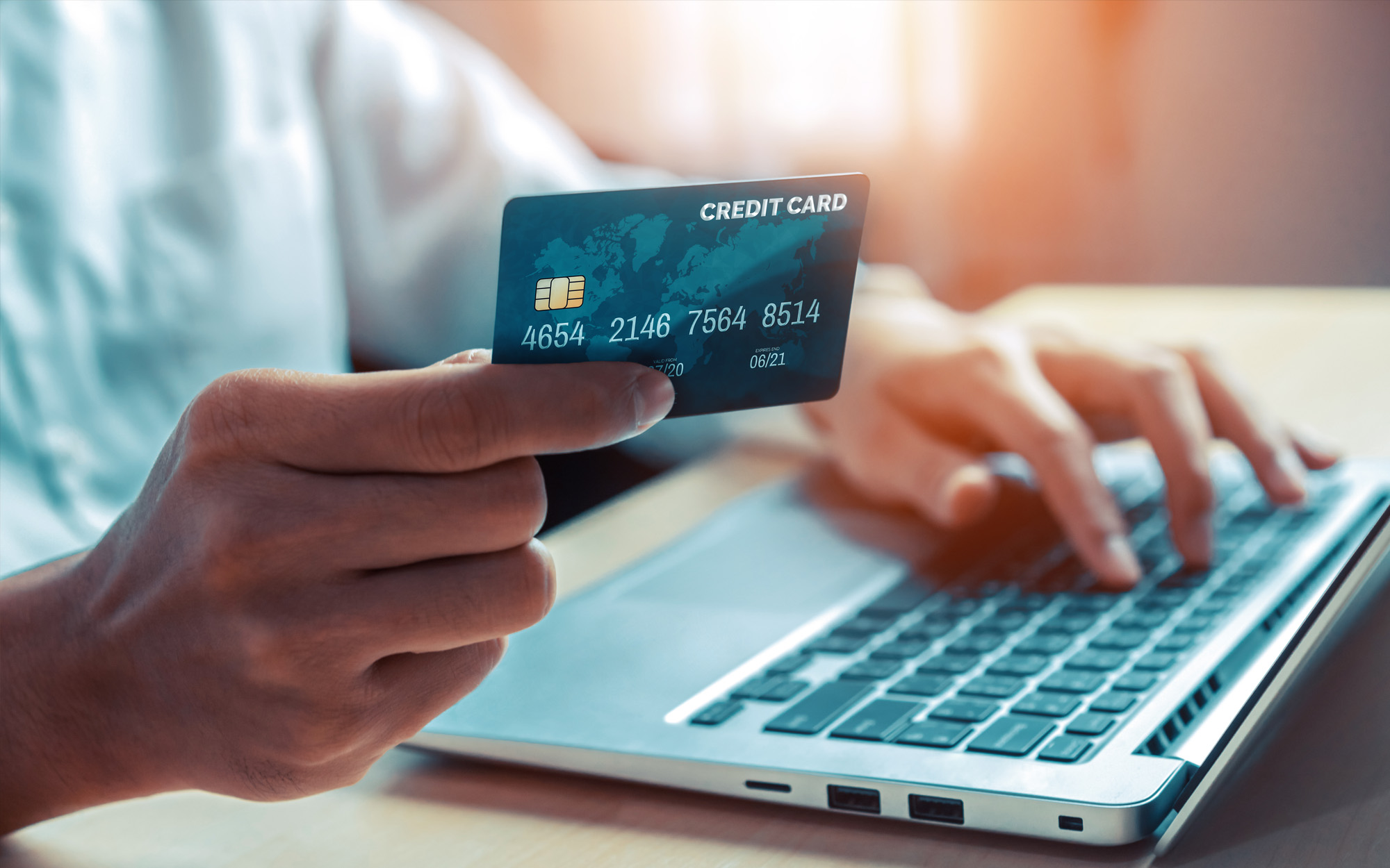 Person using credit card to make payment on computer